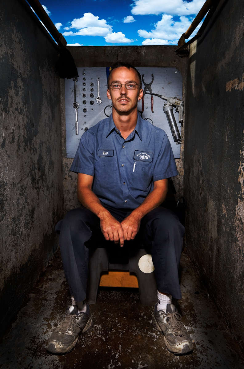Bio-diesel fuel in Texas - Eric Miles sitting inside the grease bit below ground  level with the sky showing from outside at Miles Automotive where he sells Bio-Willie (bio-diesel 